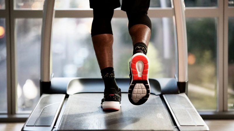 A guest running on a treadmill beside the fitness centre's windows
